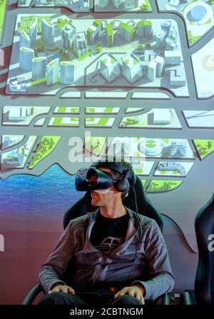 man in VR goggles sitting on a chair enjoying virtual reality demonstration at TSMC museum Stock Photo