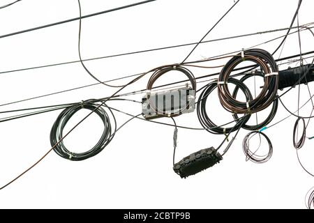 Cable wires on the electric poles are tangled on white  background , Bangkok Thailand. Stock Photo