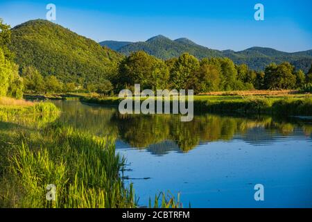 Gacka river flowing between green fields in Lika region of Croatia, beautiful landscape Stock Photo