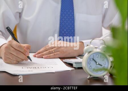 Working Businessman and White Alarm Clock. Work Time concept. Stock Photo
