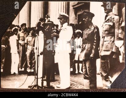 Japanese Surrender to Lord Louis Mountbatten in Singapore 12 September 1945 These original photographic prints were bought home from the far east by the photographers father in the bottom of a tool box after the war. They are in a family album and copied by this photographer Supreme Allied Commander South East Asia: The Japanese surrender in Singapore: Admiral Mountbatten delivering an address on the steps of the Municipal Building at Singapore after the surrender ceremony. Left to right: General William Slim (in slouch hat), Admiral Lord Mountbatten (at microphone, in white), Lieutenant Gener Stock Photo