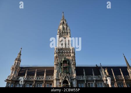New town hall in Munich, Germany with clock chimes and blue sky on sunny day Stock Photo