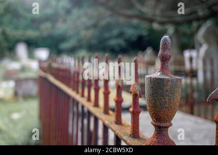 Rusty railing surrounding a decaying tomb Stock Photo