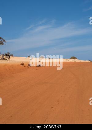 Senegal, Africa - Feb 02, 2019: Road with red and white sand at the end of the past  Paris-Dakar route Stock Photo