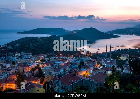 The sun sets over the fishing village of Kas on the Mediterranean coast of Turkey. Kas is a small fishing, diving, yachting and tourist town. Stock Photo