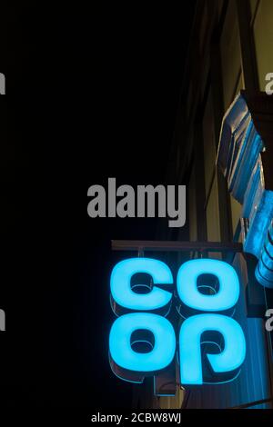 A neon blue Co-op supermarket sign at night Stock Photo
