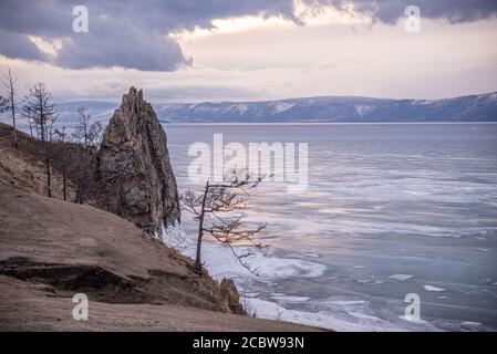 Rocky cliff Olkhons Island on frozen waters of Lake Baikal, Russia Stock Photo