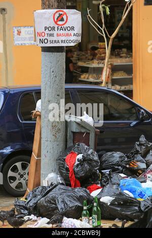 Pile of garbage on a street, under a signboard banning it, in the old city of Santo Domingo, Dominican Republic. Stock Photo