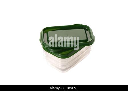Bundle of transparent plastic food containers on a white background. Plastic food containers with green lids. Close up. Copy space. Stock Photo