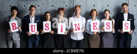 People holding BUSINESS letters printed on paper Stock Photo