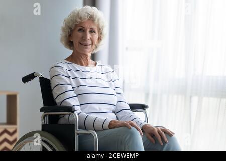 Portrait of smiling beautiful mature woman sitting in wheelchair. Stock Photo