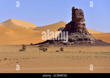 TADRART NATIONAL PARK IN ALGERIA. ROCKS AND RED SAND DUNES IN THE SAHARA DESERT. Stock Photo