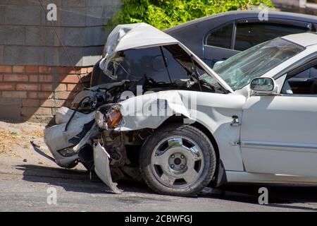 A road accident, a car that crashed, a white car on the road, cracks in the glass and a damaged bumper. Stock Photo