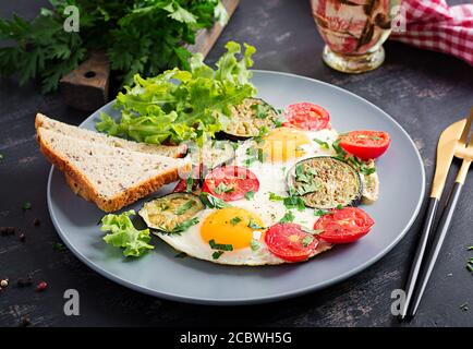 English breakfast - fried eggs, tomatoes and eggplant. American food. Stock Photo