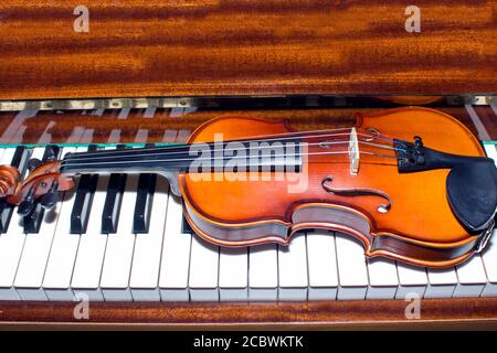 Very old violin lying on the piano Stock Photo