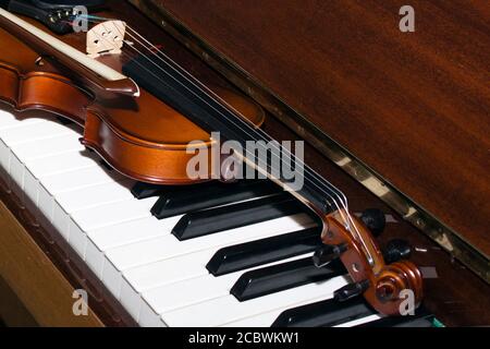 Very old violin lying on the piano Stock Photo