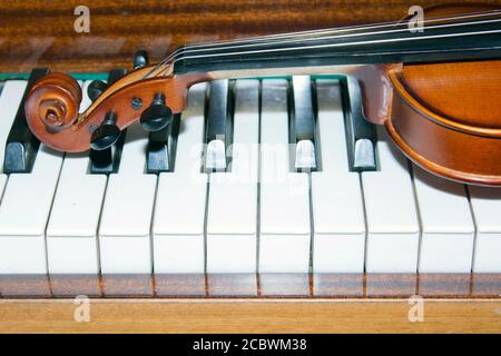 Very old violin lying on the piano Stock Photo