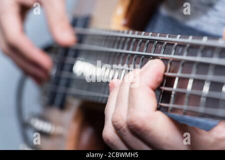 Closeup photo of bass guitar player hands, soft selective focus, live music theme Stock Photo