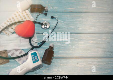A heart with a stethoscope lies on a wooden background. Healthy heart Stock Photo