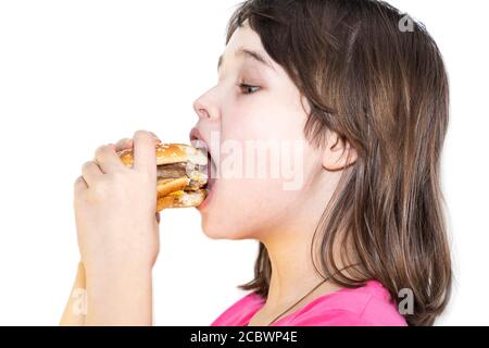 portrait of a beautiful girl, teenager and schoolgirl, holding a hamburger on a white background. Stock Photo