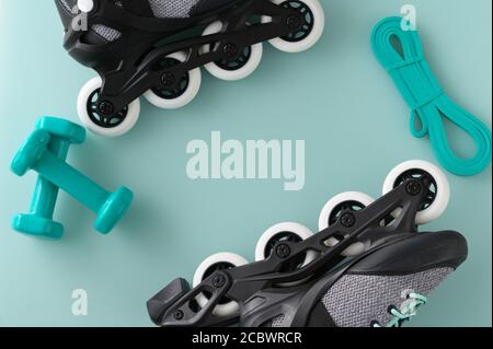 Active lifestyle and fitness border with hand weights, roller skates, and resistance band on a green background Stock Photo