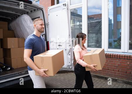 Couple Moving Boxes From Van Or Truck Together Outdoors Stock Photo