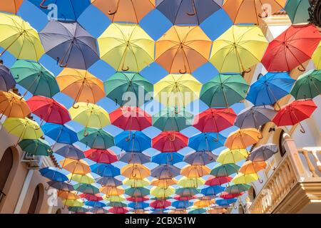 The sky is full of colorful umbrellas. Street with umbrellas in the sky in the village San Bartolome de la torre. Summer decoration and sun  protectio