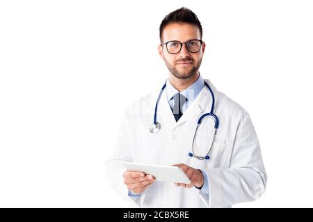 Studio shot of male doctor holding digital tablet in his hand while standing at isolated white background. Copy space. Stock Photo