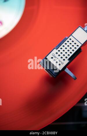 Red vinyl record playing on a turntable Stock Photo