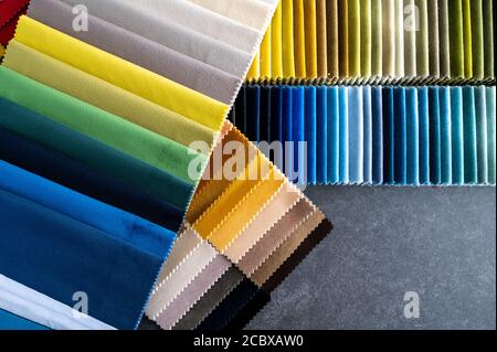 Multiple colorful samples of luxury velvet fabrics placed on a stone table as flat lay top down with copy space Stock Photo