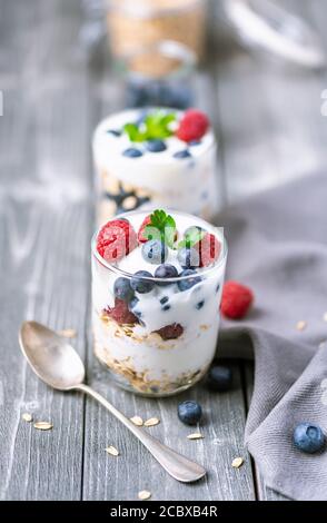 White yogurt with granola and blueberries and raspberries on the top. Stock Photo