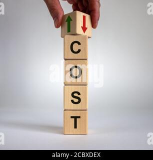 Hand is turning a cube and changes the direction of an arrow symbolizing that the cost is going down or vice versa. Beautiful white background, copy s Stock Photo