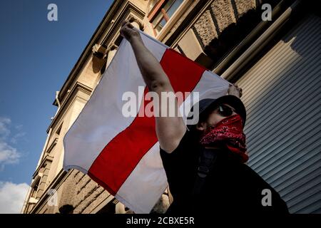 Moscow, Russia. 16th of August, 2020 A demonstrator holds a former white-red-white flag of Belarus used in opposition to the government during a protest against the results of Belarusian presidential election outside the Belarusian embassy in Moscow, Russia Stock Photo
