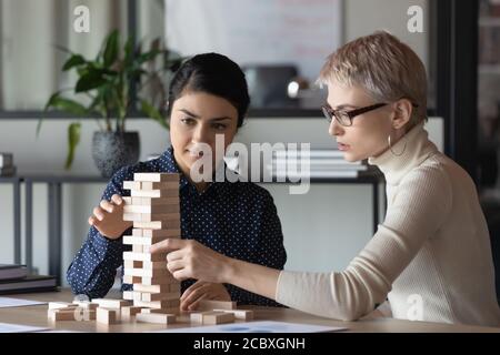 Concentrated mixed race employees developing strategic thinking in game activity. Stock Photo