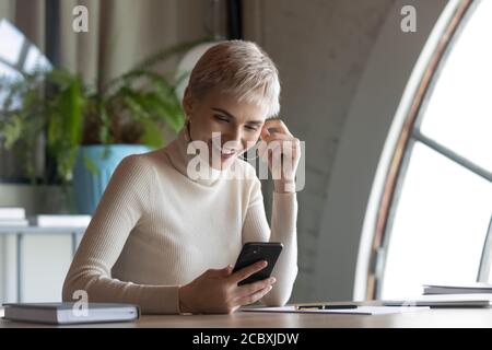 Happy young businesswoman using mobile software application. Stock Photo