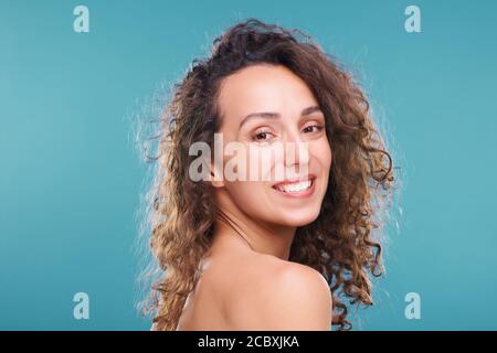 Cheerful young female with healthy skin and toothy smile looking at camera Stock Photo