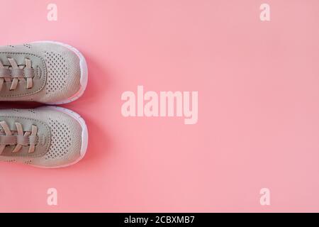 Sport, healthy lifestyle concept. New gray sneakers on pastel pink background. Copy space. Flat lay. Close-up. Stock Photo