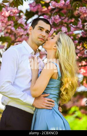 We love kissing. spring flower bloom. man and woman in park with