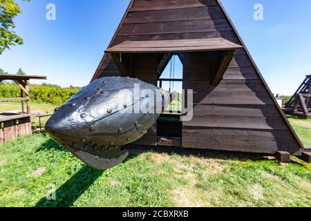 A siege machine standing on the grass in the museum. Medieval wooden machines used for the siege of castles. Summer season. Stock Photo