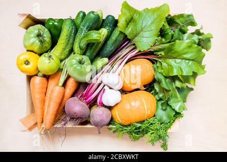 Top view fresh organic vegetables in eco friendly wooden box on wooden background. flat lay Stock Photo