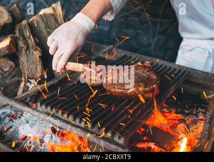 Chef Cooking steak. Cook turns the meat on the fire Stock Photo - Alamy