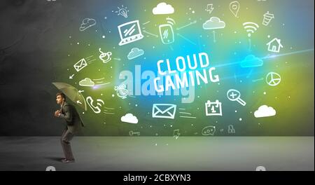Businessman defending with umbrella from CLOUD GAMING inscription, modern technology concept Stock Photo