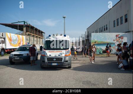 Several young people are seen waiting to get tested for Covid-19 near an ambulance.Following the closure of discotheques and musical entertainment in all Calabria, after a boy was confirmed with Covid-19 having  stayed two nights in Soverato’s discotheques, the Civil Protection and the Provincial Sanitary Authority provided a tent for those in need of a Covid-19 test, in the well known touristic city. Tests had been carried all day long and were suspended on August 15th (National Holiday) to be continued on the following day, in order to reassure and provide safety for local people and tourist Stock Photo