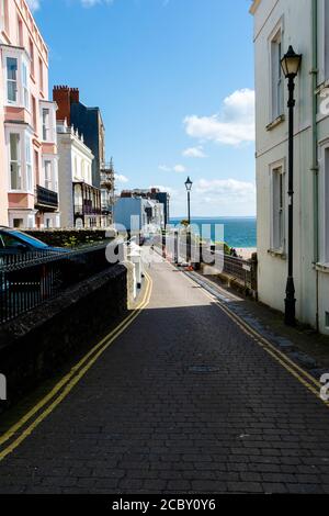 A view of multi-coloured houses in a typical street in Tenby, Pembrokeshire on a sunny day Stock Photo