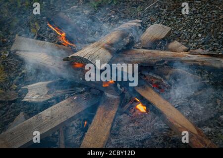 Burning log of wood close-up as abstract background. The hot embers of burning wood log fire. Stock Photo