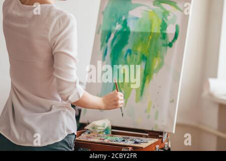 woman is bad at painting. beginner of painting. first day in art classes. close up back view photo Stock Photo
