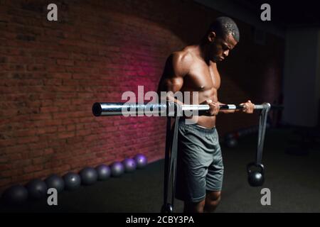 African man lifting a bar with weights in gym. Active People Sport Workout Concept Stock Photo