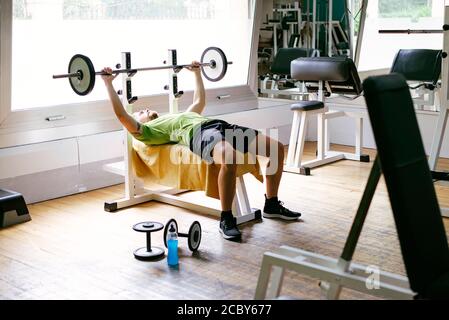 Bearded guy lifting weights at the gym Stock Photo