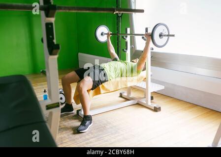 Bearded guy lifting weights at the gym Stock Photo