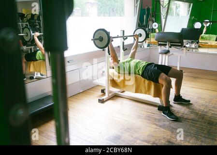 Bearded guy lifting weights at the gym Stock Photo